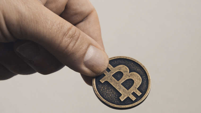 Une pièce Bitcoin dans une main